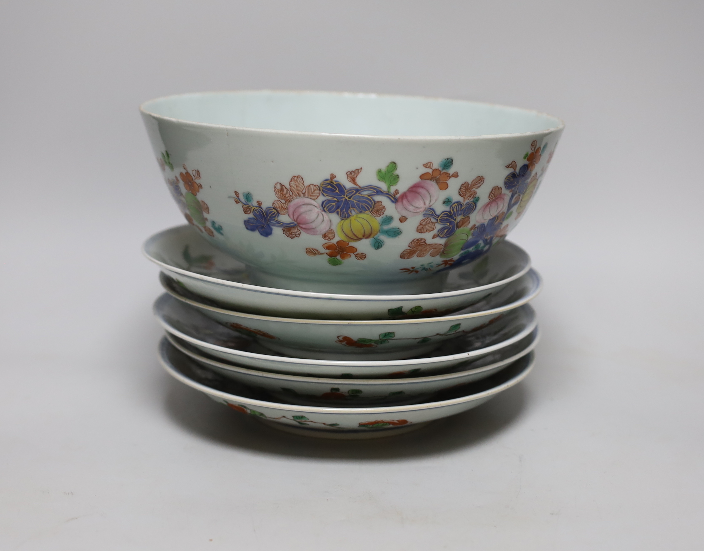 An 18th century Chinese famille rose bowl and a group of five Chinese wucai plates, each decorated with fruit, the bowl 23cm in diameter